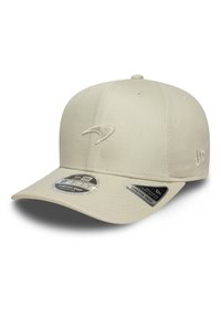 Beige cap with a rounded crown, flat visor, and embroidered logo. Features stretch-snap adjustment and is made from a textured fabric.