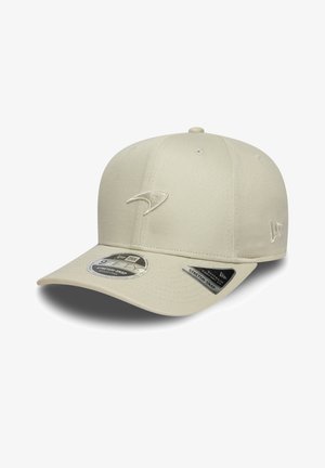 Beige cap with a rounded crown, flat visor, and embroidered logo. Features stretch-snap adjustment and is made from a textured fabric.