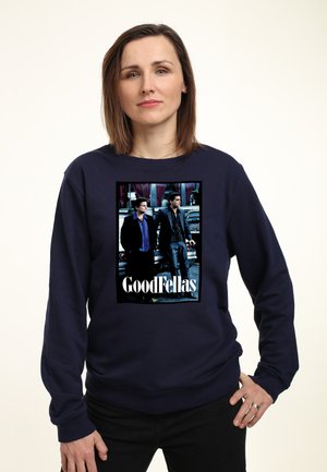 Granatowy sweatshirt z nadrukiem z przodu przedstawiającym dwie postacie z filmu "Chłopcy z Ferajny", z pogrubionym białym tekstem na dole.