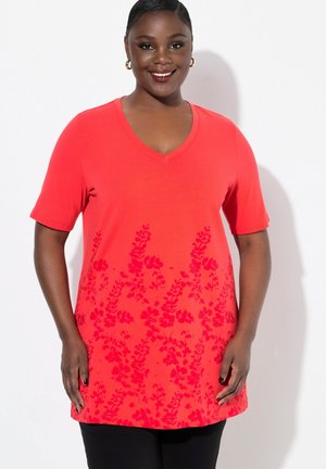 T-shirt rouge à col en V avec des manches courtes, présentant un motif floral dans une teinte rouge plus foncée sur la moitié inférieure. Tissu doux, coupe décontractée.