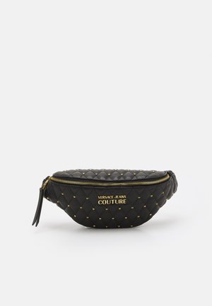 Riñonera de cuero negro acolchado con tachuelas doradas, cremallera dorada y logo "Versace Jeans Couture" en el frente.