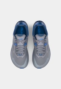 Grijze hardloopschoenen met een mesh bovenwerk, blauwe accenten, een ronde neus, een gestructureerde zool en platte veters. Opvallende blauwe tab aan de hiel.