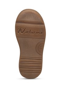 Suola in gomma marrone con superficie texture, caratterizzata da scanalature orizzontali, un accento circolare e il logo "Naturino" in rilievo.