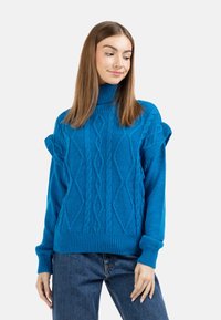 Pulover albastru din tricot cu model cu ochiuri, cu guler înalt și mâneci bufante, având modele texturate în formă de diamant și tivuri și manșete cu dungi.