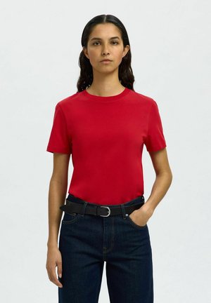 Röd kortärmad t-shirt i mjukt tyg med rund halsringning. Bärs tillsammans med mörkblå jeans och ett svart bälte. Enkelt design.