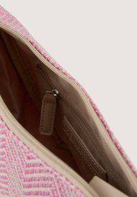 Geweven roze stoffen pouch met een beige interieur, een ritsvak en een leren label. Het binnenvoering is glad en lichtbruin.