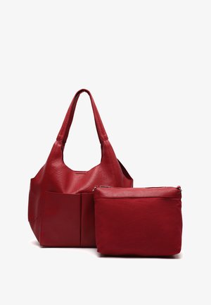 Sac fourre-tout en cuir rouge avec deux poignées et une finition texturée, associé à un petit pochon rouge présentant une surface lisse et une fermeture éclair.