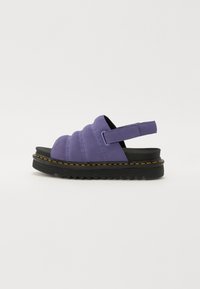 Lilla semsket sandal med polstret overdel, svart gummisåle og gul s�øm. Justerbar bakre stropp og formet såle for støtte.