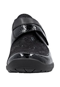 Chaussure noire avec une finition en vernis texturé, dotée d'une sangle Velcro. Forme de bout arrondi et semelle en caoutchouc avec des détails de grip.