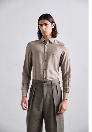 Chemise marron clair à manches longues avec un subtil éclat et des boutons foncés ; associée à un pantalon taille haute olive ajusté.