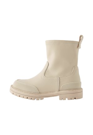 Stivaletto beige in pelle liscia con suola in gomma testurizzata, pannelli elasticizzati laterali e pull tab sul retro per una facile calzata.