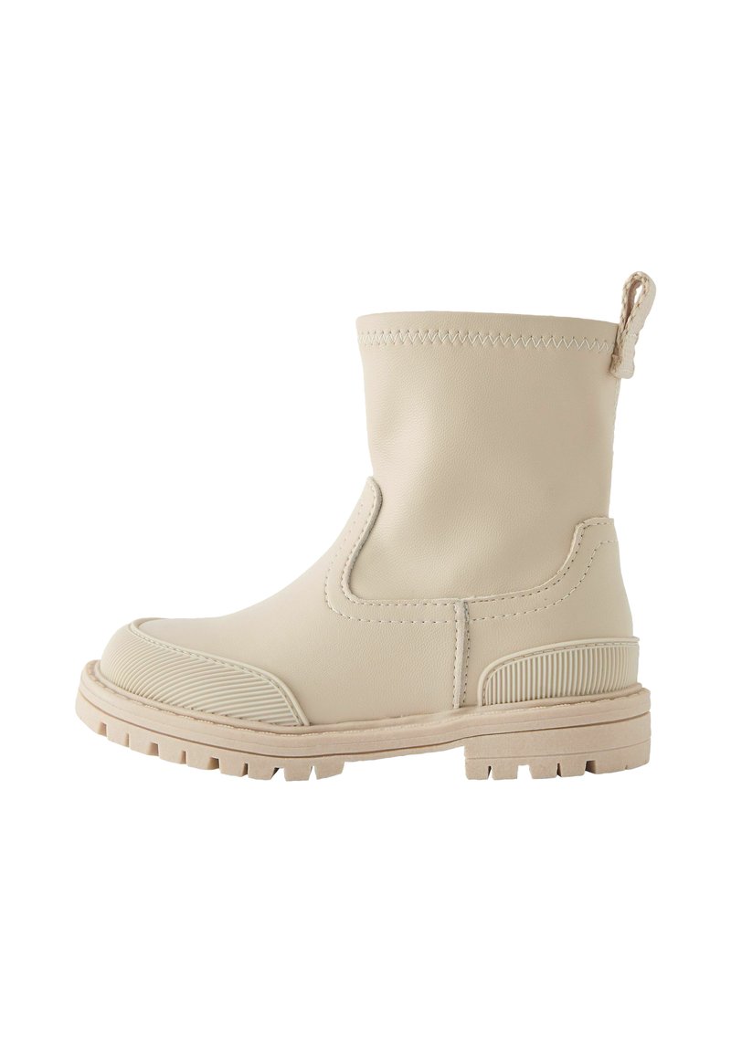 Botte beige à la cheville en cuir lisse avec une semelle en caoutchouc texturé, des panneaux élastiques sur les côtés et une languette à l'arrière pour un enfilage facile.