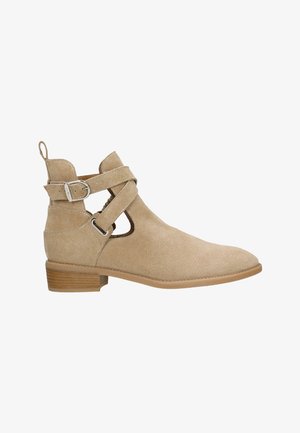 Béžové semišové kotníkové boty s vykrojeným designem a páskem se stříbrnou sponou. Plochý dřevěný podpatek a hladká špička.