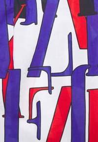 Flerfärgad tyg som har djärva, abstrakta former i lila, röd och svart på en vit bakgrund; slät textur med tydliga konturer.