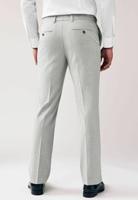Pantalones de corte entallado en gris claro con un acabado texturizado, que presentan bolsillos traseros con botones y un diseño de pierna recta.