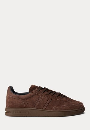 Basket basse en daim marron avec lacets sur le devant et « Ralph Lauren » embossé sur la semelle latérale, présentée sur un fond uni.