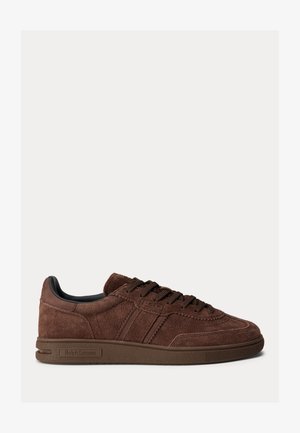 Basket basse en daim marron avec lacets sur le devant et « Ralph Lauren » embossé sur la semelle latérale, présentée sur un fond uni.
