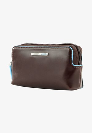 Bruine leren pouch met blauwe accenten. Voorzien van een ritssluiting en een klein zilveren logo aan de voorkant. Compact rechthoekig van vorm.