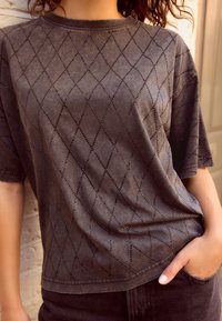 T-shirt in cotone grigio con un motivo a diamante di piccole strass, maniche corte e scollatura rotonda. Vestibilità casual con una texture liscia.