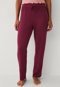 Burgundy pajama pants made of soft, lightweight fabric with an elastic waistband and drawstring. Features a straight leg design.
