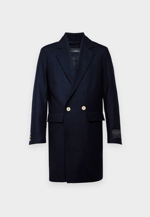 Marineblauer Wollmantel mit doppelter Knopfleiste, ausgestattet mit goldenen Knöpfen, Reverskragen und zwei Fronttaschen. Glatte Textur, knielang.