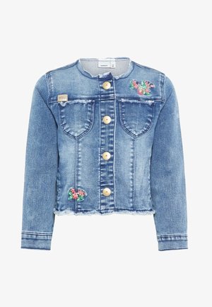 Giacca di denim blu con bordi sfrangiati, bottoni dorati sulla parte anteriore, due tasche sul petto e piccolo ricamo floreale sul petto e sul lato inferiore.