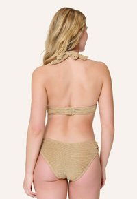 Set di bikini in tessuto oro testurizzato, scollo a halter con dettaglio a fiocco, spallina regolabile sul retro e slip bikini a vita bassa coordinati.