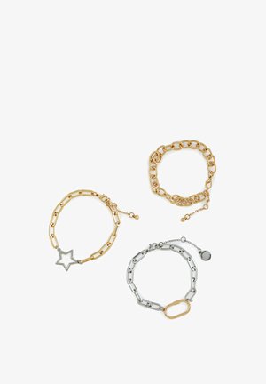Three bracelets: one gold chain with a star charm, one thick gold link chain, and one silver link chain with a gold clasp.
