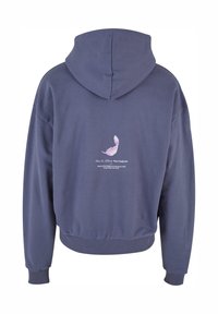 Purple hoodie with a drawstring hood. Back features a pink feather graphic and text reading "Liberty is the freedom to live as you wish."