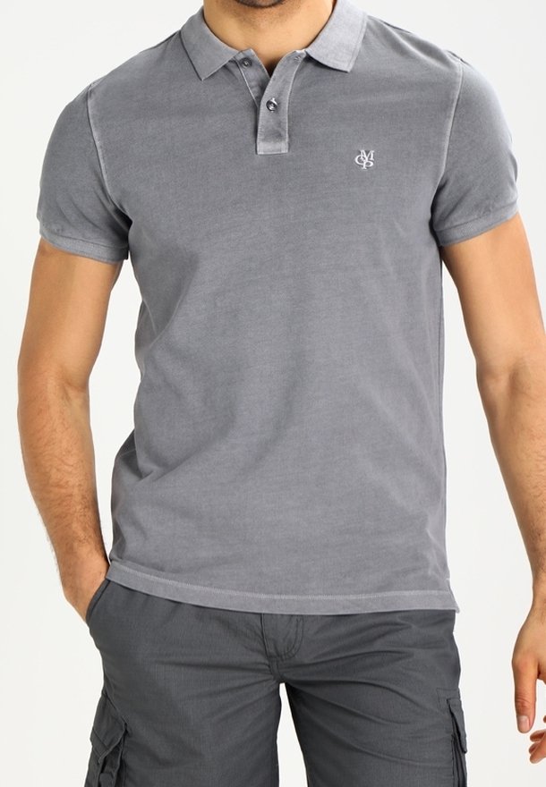 Homme portant un polo gris cintré à manches courtes avec un petit logo blanc brodé sur la poitrine et un short cargo gris foncé.