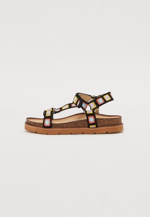 Black sandals with colorful embroidery and adjustable straps. Cork footbed on a rubber sole, featuring a textured design for grip.