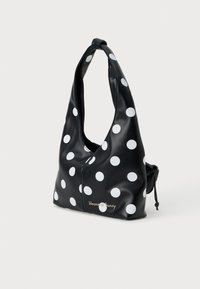 Zwarte tas met polkadots, gemaakt van glad faux leer. Heeft een slouchy vorm, een oversized handvat en een trekkoordsluiting met branding aan de voorkant.