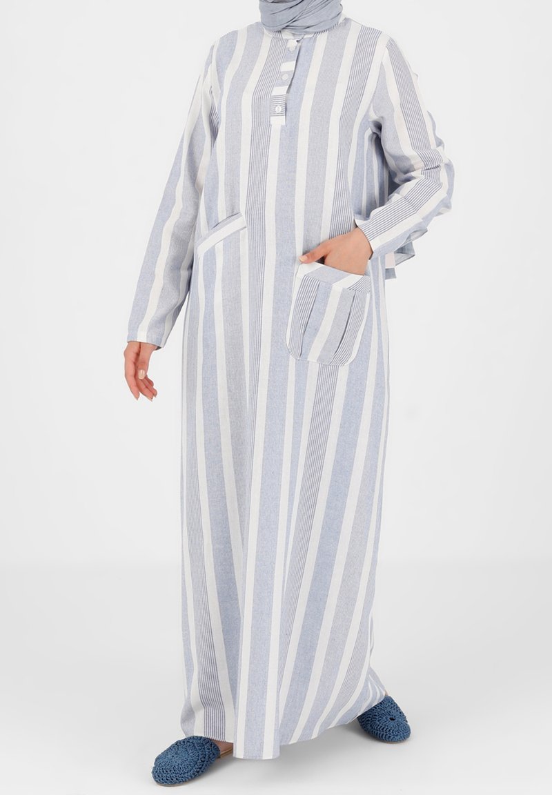 Długa sukienka w paski w kolorze jasnoniebieskim i białym, z zapięciem na guziki, długimi rękawami, boczną kieszenią i luźnym krojem.