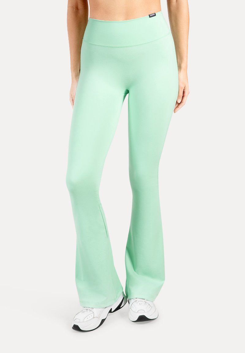 Leggings évasés vert menthe en tissu extensible avec une taille haute. Caractérisés par une texture lisse et un branding minimaliste sur la ceinture.