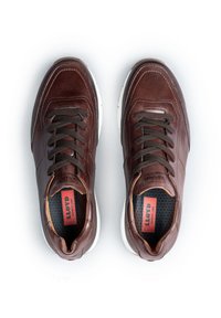 Sneakers in pelle marrone con punta rotonda, superficie testurizzata, lacci scuri a contrasto, suola bianca e logo sulla linguetta interna.