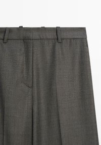 Grå vävda byxor med en slät struktur, som har en standard midja, bältesörhängen och en framficka.