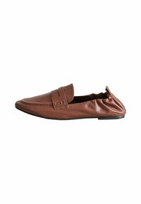 Mocassino in pelle marrone con punta arrotondata, fascia decorativa e cuciture elastiche per una vestibilità aderente. Suola nera piatta con minimalismo nel battistrada.