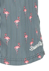 Sininen ja valkoinen raidallinen naisten hihaton paita, jossa on vaaleanpunaisia flamingokuvioita ja valkoinen logo-embroideeraus helmaarilla.
