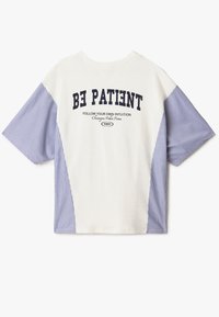 Camiseta de cuello redondo con un cuerpo blanco y mangas a rayas azules. Presenta un texto en negrita en la parte posterior: "SE PACIENTE" y detalles gráficos en color marino.