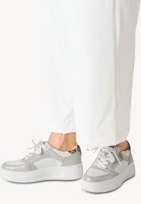 Sneaker argento e bianco con pannelli testurizzati, punta rotonda, chiusura con lacci e suola platform; presenta accenti con stampa animale sul tallone.
