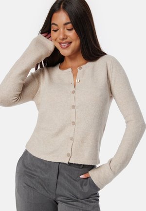 Beige knoop cardigan met zachte textuur en lange mouwen, met een ronde hals en vijf knopen aan de voorkant, ontworpen voor een losse pasvorm.