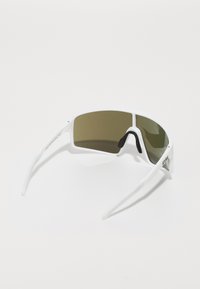 Weiße Sonnenbrille mit einem Wraparound-Design, ausgestattet mit grün getönten Gläsern, Gummi-Nasenpads und dünnen Bügeln. Mit einem dezenten Logo akzentuiert.