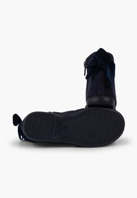 Stivali ankle in suede blu navy con cerniera laterale, dettaglio a fiocco in tessuto e suola in gomma testurizzata con pattern per grip.