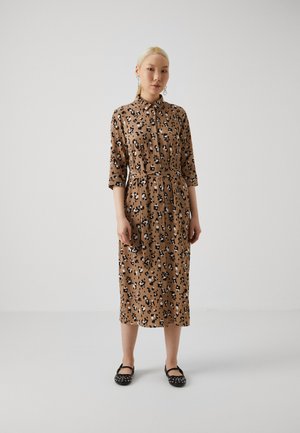 Brown button-up dress with black and cream leopard print, three-quarter sleeves, cinched waist, knee-length, paired with black flat shoes.