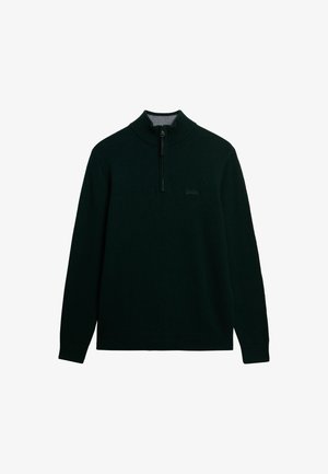 Pull-over vert foncé avec un col montant et une fermeture éclair. Fabriqué en tissu doux, avec un logo de marque discret sur la poitrine.