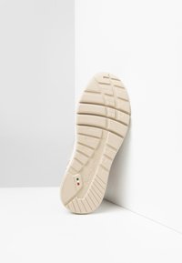 Suela de zapato beige con patrones de agarre texturizados, que presenta un logo que dice "NeroGiardini" y un pequeño detalle de la bandera italiana.