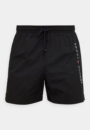 Black swim shorts with a drawstring waist, made from lightweight fabric. Features "TOMMY HILFIGER" logo in white on the side.