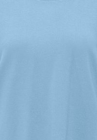 Tissu bleu clair avec une texture douce et lisse, probablement une partie d'un vêtement.