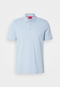 Polo bleu clair à manches courtes avec trois boutons et un col, avec un petit logo embossé sur la poitrine et une étiquette intérieure rouge au col.