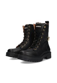 Bottines en cuir noir avec une finition texturée, œillets en or, un talon marron contrastant et un accent métallique au niveau de la cheville. Design de semelle robuste.